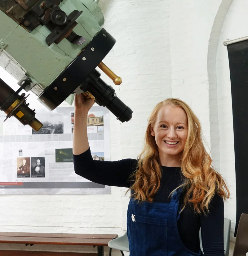 Dr Sarah Crick with a telescope