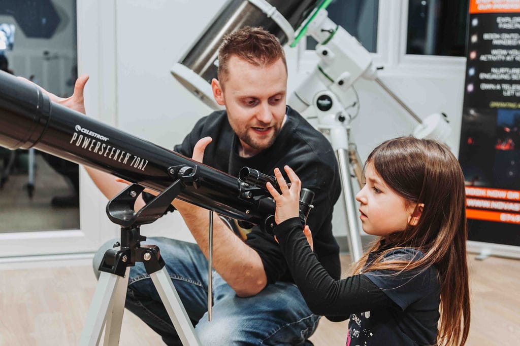 a young child looking through a telescope at a mission astro stargazing event